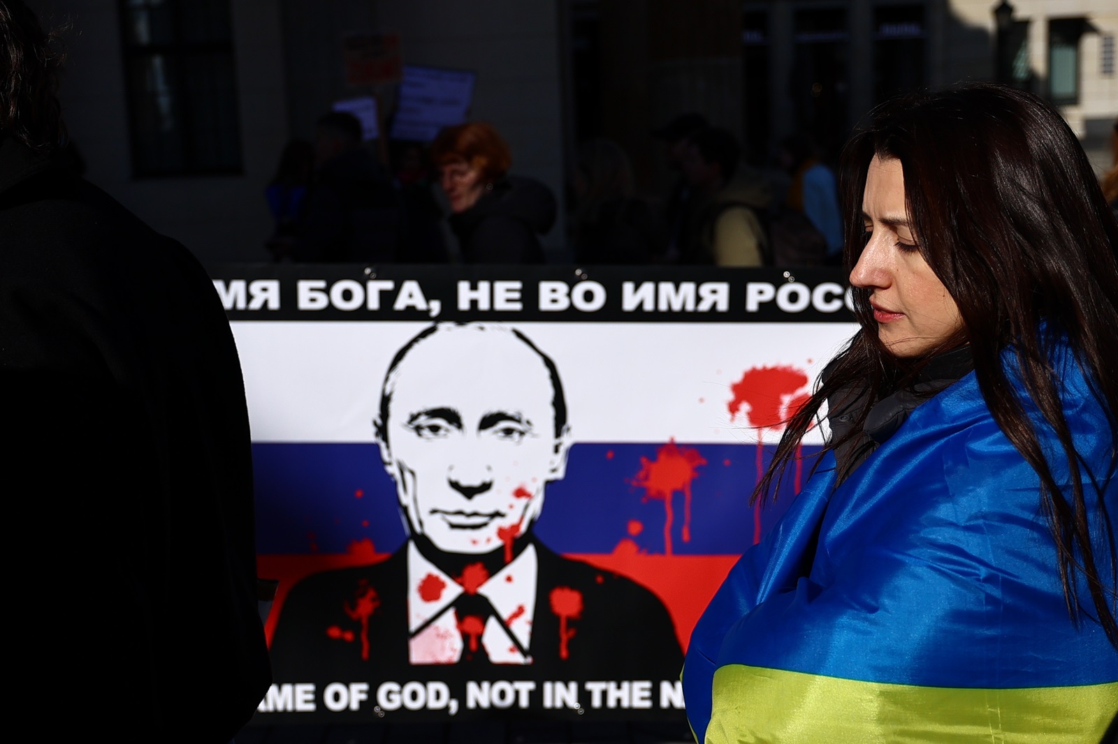 epa11177589 A participant stands next to a banner against Russian President Vladimir Putin during a demonstration in support of Ukraine, on the second anniversary of Russia's invasion of Ukraine, in Berlin, Germany, 24 February 2024. Ukraine on 24 February marks the second year since Russian troops entered its territory, starting a conflict that has provoked destruction and a humanitarian crisis.  EPA/FILIP SINGER