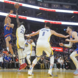 New York Knicks forward Bojan Bogdanovic (44) passes the ball while being defended by Golden State Warriors forward Draymond Green (23) during the first half of an NBA basketball game in San Francisco, Monday, March 18, 2024. (AP Photo/Jeff Chiu)