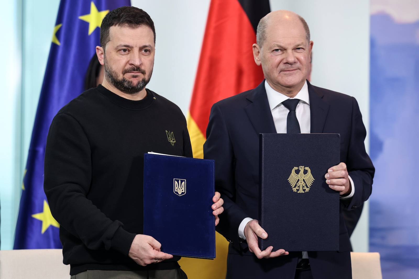 epa11157555 German Chancellor Olaf Scholz (R) and Ukraine's President Volodymyr Zelensky (L) pose after signing a 'Bilateral agreement on security commitments and long-term support' during a meeting at the German Chancellery building during Zelenskyâ€™s visit to Berlin, Germany, 16 February 2024.  EPA/CLEMENS BILAN