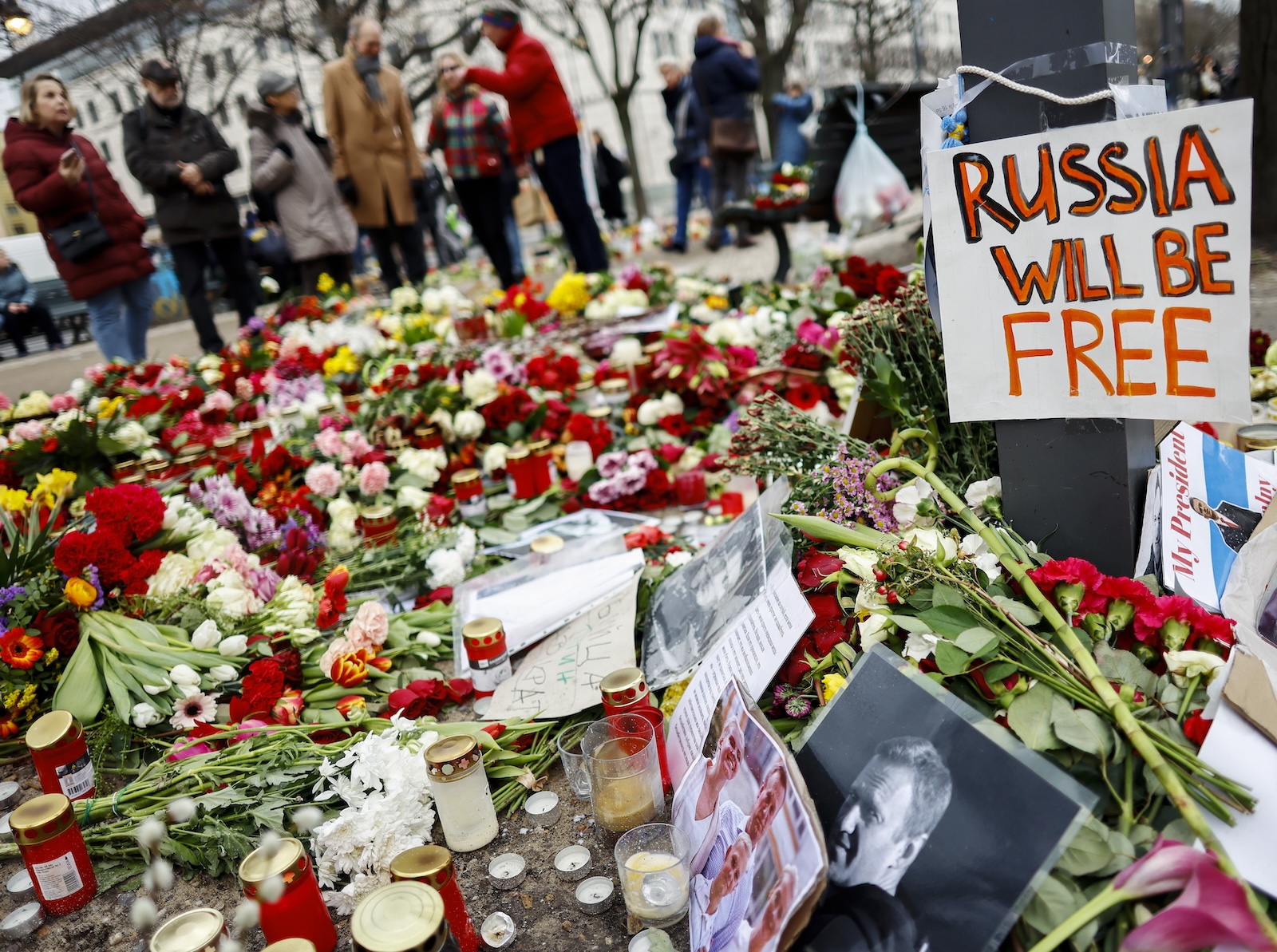 epa11170435 A photo showing late Russian opposition leader Alexei Navalny sits among floral tributes outside the Russian embassy in Berlin, Germany, 21 February 2024. Outspoken Kremlin critic Alexei Navalny died in a penal colony, the Federal Penitentiary Service of the Yamalo-Nenets Autonomous District announced on 16 February 2024. In late 2023 Navalny was transferred to an Arctic penal colony, considered one of the harshest prisons.  EPA/HANNIBAL HANSCHKE