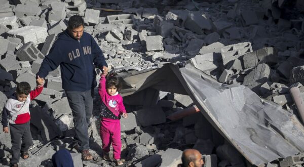 epa11198392 A Palestinian man with two children walks among the rubble of a destroyed house following Israeli air strikes in Al Nusairat refugee camp, Gaza Strip, 04 March 2024. More than 30,500 Palestinians and over 1,300 Israelis have been killed, according to the Palestinian Health Ministry and the Israel Defense Forces (IDF), since Hamas militants launched an attack against Israel from the Gaza Strip on 07 October 2023, and the Israeli operations in Gaza and the West Bank which followed it.  EPA/MOHAMMED SABER