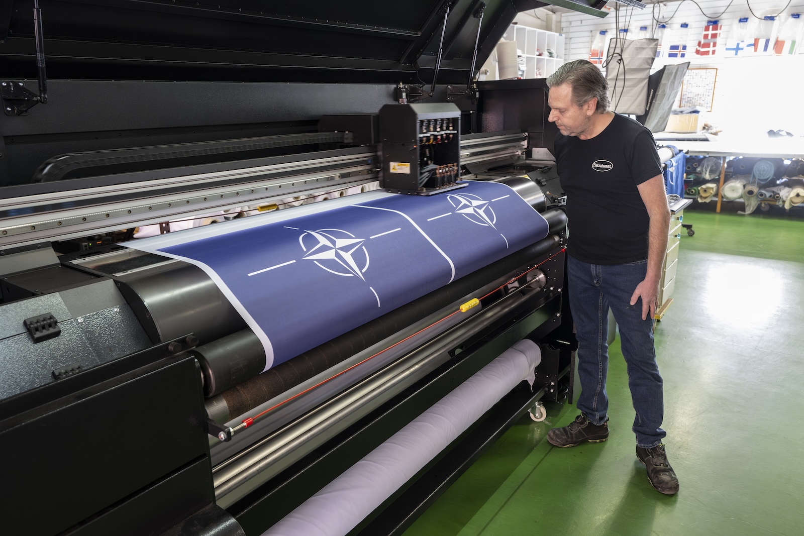 epa11204073 Stig Kvarnryd, CEO of flag manufacturer 'Flagghuset', watches as new NATO flags are printed in the factory in Akersberga, outside Stockholm, Sweden, 07 March 2024. At the family business in Akersberga, printing the blue NATO flag is in full swing ahead of Sweden's accession to NATO, as municipalities, authorities and businesses want to be ready to raise the new flag. Hungaryâ€™s president ratified Stockholmâ€™s accession documents on 05 March, paving the way for the accession of the Nordic country to the alliance.  EPA/Anders Wiklund SWEDEN OUT