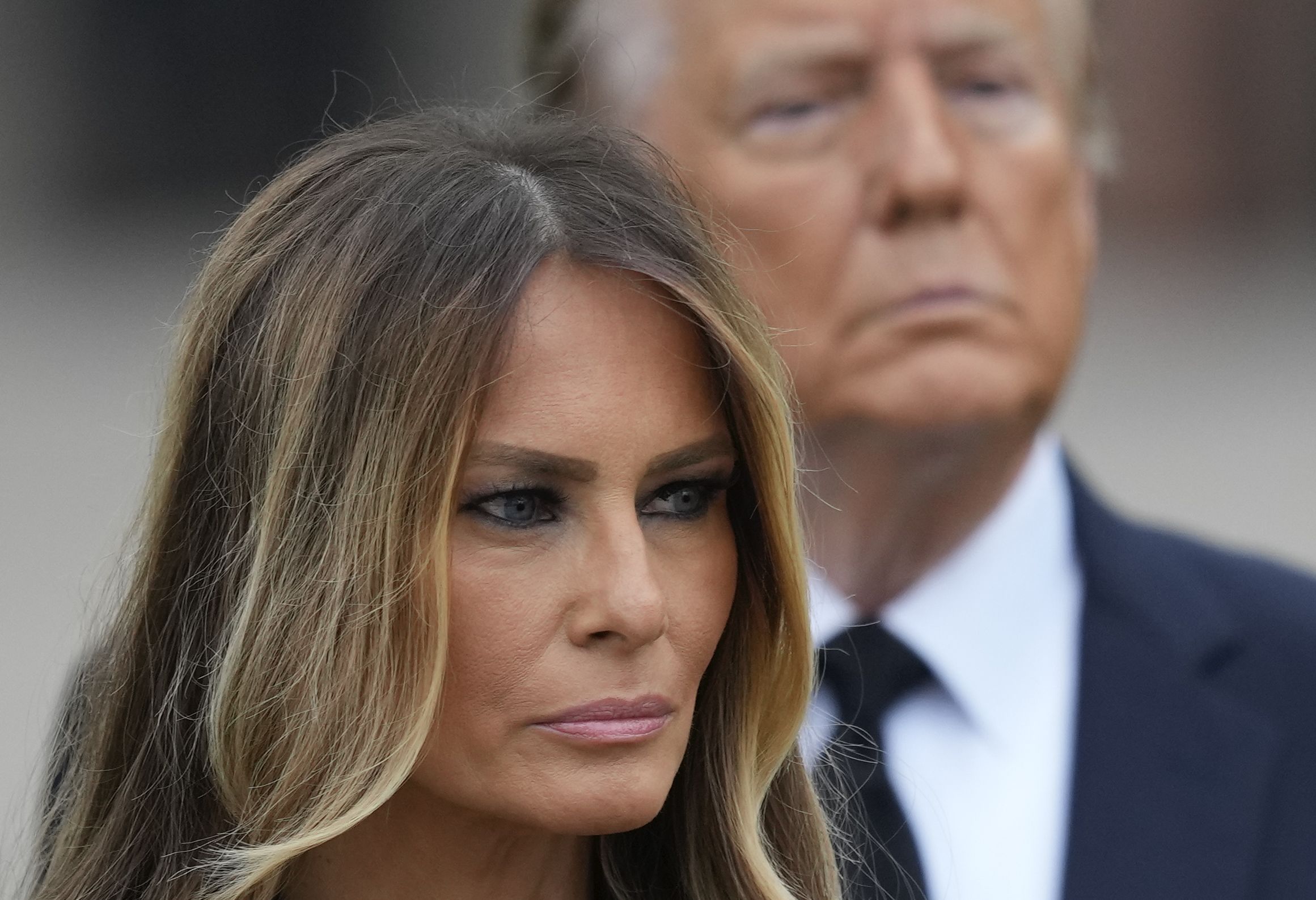 Former President Donald Trump stands behind his wife Melania as she watches pallbearers carry the coffin of her mother, Amalija Knavs, Thursday, Jan. 18, 2024, at the Church of Bethesda-by-the-Sea in Palm Beach, Fla. (AP Photo/Rebecca Blackwell)