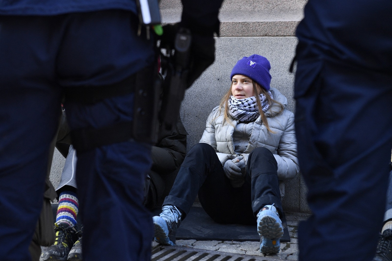 Swedish climate activist Greta Thunberg looks at policemen as she sits outside the Swedish parliament, the Riksdagen, to demonstrate for climate action, on March 12, 2024 in Stockholm, Sweden.,Image: 856121108, License: Rights-managed, Restrictions: Sweden OUT, Model Release: no, Credit line: Samuel STEEN / AFP / Profimedia