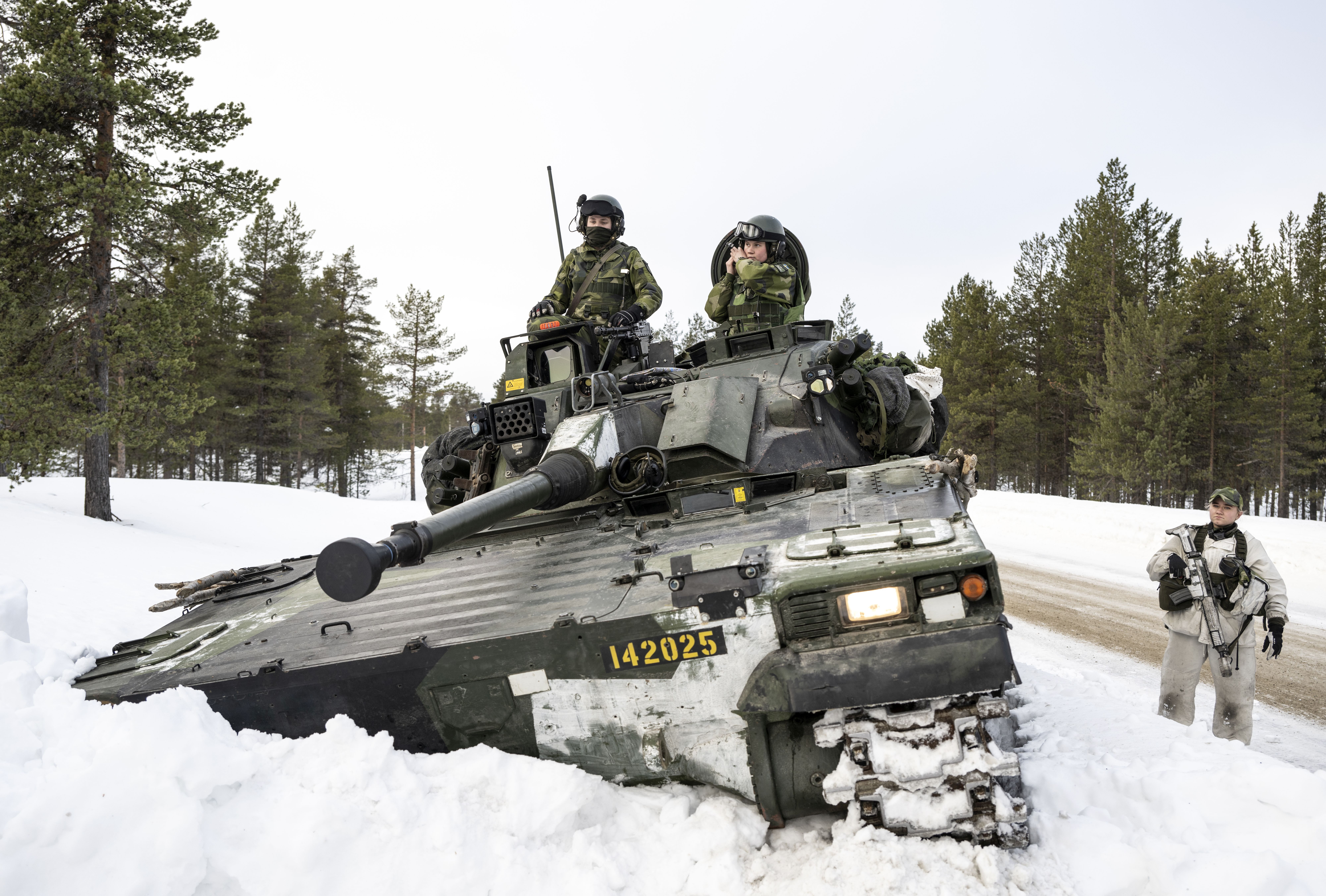 epa11200216 Swedish soldiers from the Norrlandsbrigade in Boden on a combat vehicle 90 during training together with Finnish hunting units in Hetta, northern Finland, 05 March 2024. The exercise is part of Nordic Response, which is a Norwegian national exercise that is carried out in northern Sweden, Norway and Finland with associated airspace and waters. According to the NATO, military staff from 13 NATO Allies and Partners will be participating in exercise Nordic Response 2024, part of the Steadfast Defender exercise series, in Norway, Finland and Sweden, running between 03 to 14 March.  EPA/Anders Wiklund SWEDEN OUT