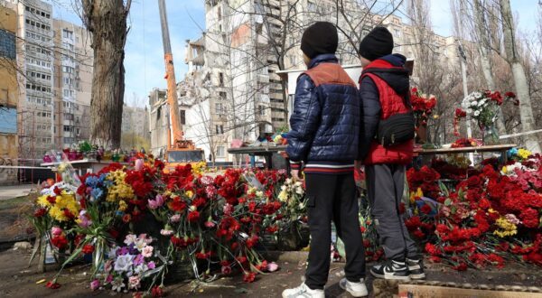 Non Exclusive: ODESA, UKRAINE - MARCH 27, 2024 - Boys stand by the heaps of flowers brought by people to the site of the tragedy as part of the section of a 9-story residential building on Dobrovolskoho Avenue collapsed, hit by a Russian drone on March 2, the dismantling works are underway, Odesa, southern Ukraine.,Image: 860480439, License: Rights-managed, Restrictions: This photo cannot be distributed in the Russian Federation. MANDATORY CREDIT OR DOUBLE FEE WILL BE CHARGED - **Strictly no use in repeat online galleries without payment**, Model Release: no, Credit line: / BEEM / Beem / Profimedia