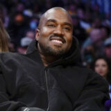 FILE - Kanye West, known as Ye, watches the first half of an NBA basketball game between the Washington Wizards and the Los Angeles Lakers, on March 11, 2022, in Los Angeles. Adidas said Wednesday March 13, 2024 that it's donated or is planning to give away more than $150 million to groups fighting antisemitism and other forms of hate from the sales of Yeezy shoes last year after it severed ties with Ye, the rapper formerly known as Kanye West. (AP Photo/Ashley Landis, File)