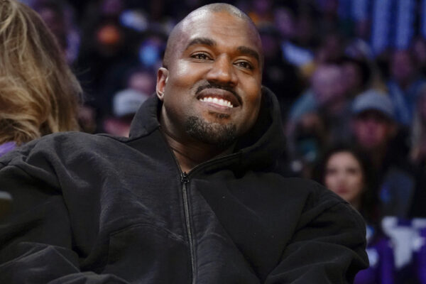 FILE - Kanye West, known as Ye, watches the first half of an NBA basketball game between the Washington Wizards and the Los Angeles Lakers, on March 11, 2022, in Los Angeles. Adidas said Wednesday March 13, 2024 that it's donated or is planning to give away more than $150 million to groups fighting antisemitism and other forms of hate from the sales of Yeezy shoes last year after it severed ties with Ye, the rapper formerly known as Kanye West. (AP Photo/Ashley Landis, File)