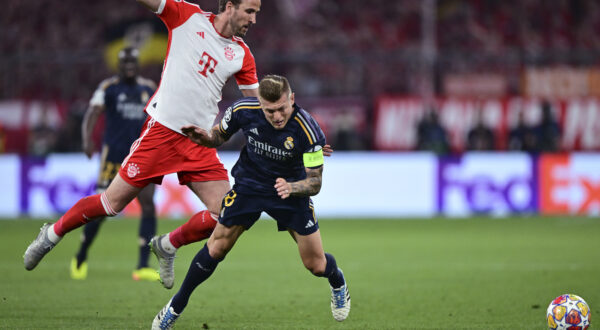 Bayern's Harry Kane, left, challenges for the ball with Real Madrid's Toni Kroos during the Champions League semifinal first leg soccer match between Bayern Munich and Real Madrid at the Allianz Arena in Munich, Germany, Tuesday, April 30, 2024. (AP Photo/Christian Bruna)