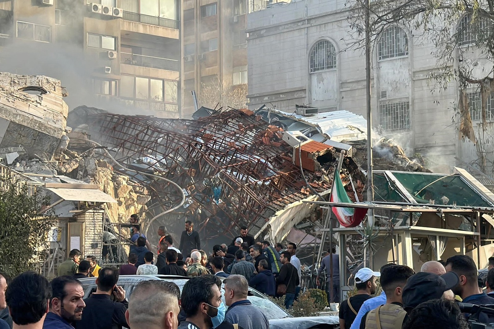 Emergency and security personnel gather at the site of strikes which hit a building adjacent to the Iranian embassy in Syria's capital Damascus, on April 1, 2024. Israeli strikes hit Syria's capital on April 1, state media reported, as a war monitor said six people were killed in a building adjacent to the Iranian embassy.,Image: 861588127, License: Rights-managed, Restrictions: , Model Release: no, Credit line: Maher AL MOUNES / AFP / Profimedia