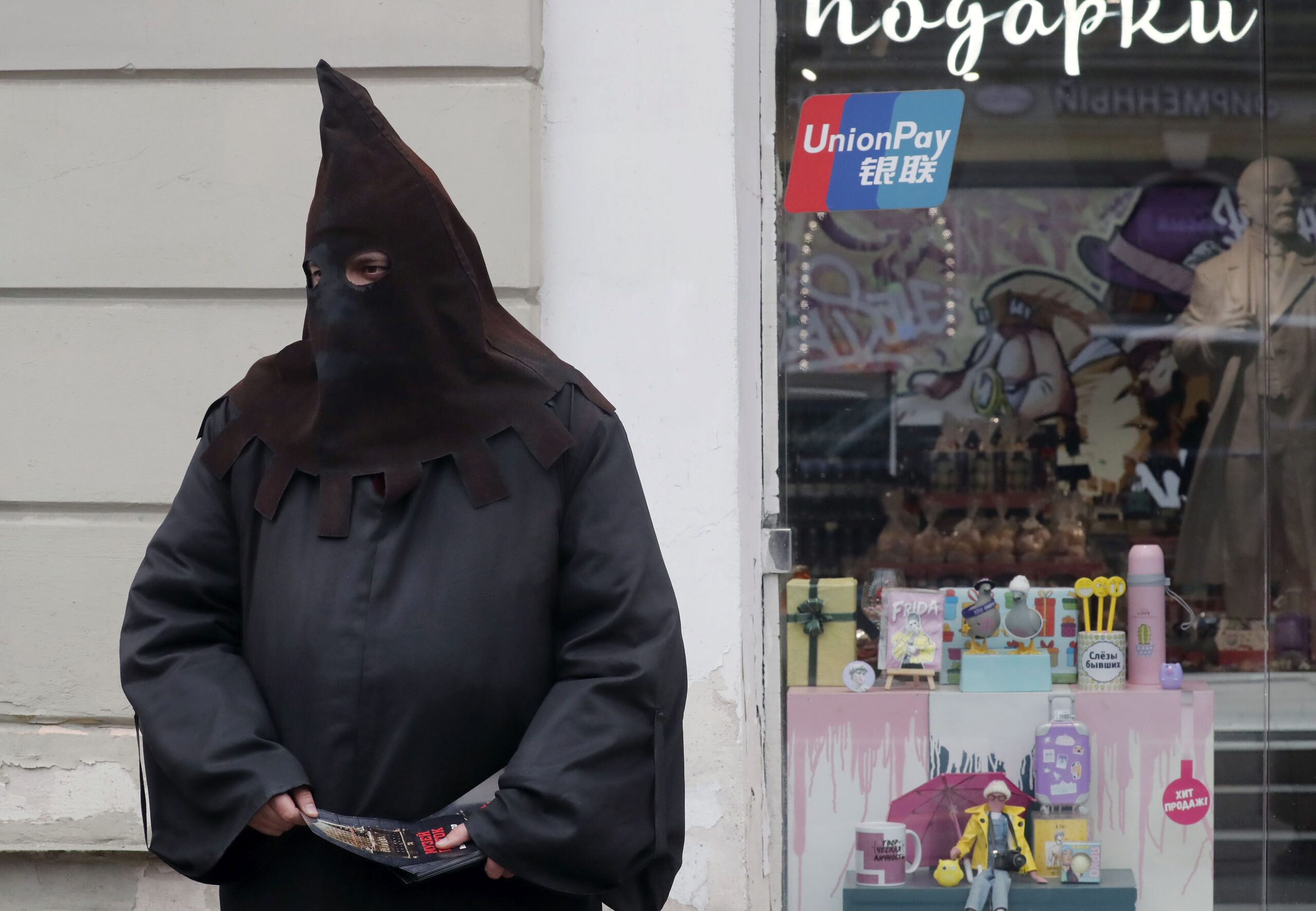 epa11284861 A man dressed as an Inquisition executioner invites pedestrians to the Museum of Torture at the Nevsky Prospect avenue in St. Petersburg, Russia, 17 April 2024.  EPA/ANATOLY MALTSEV