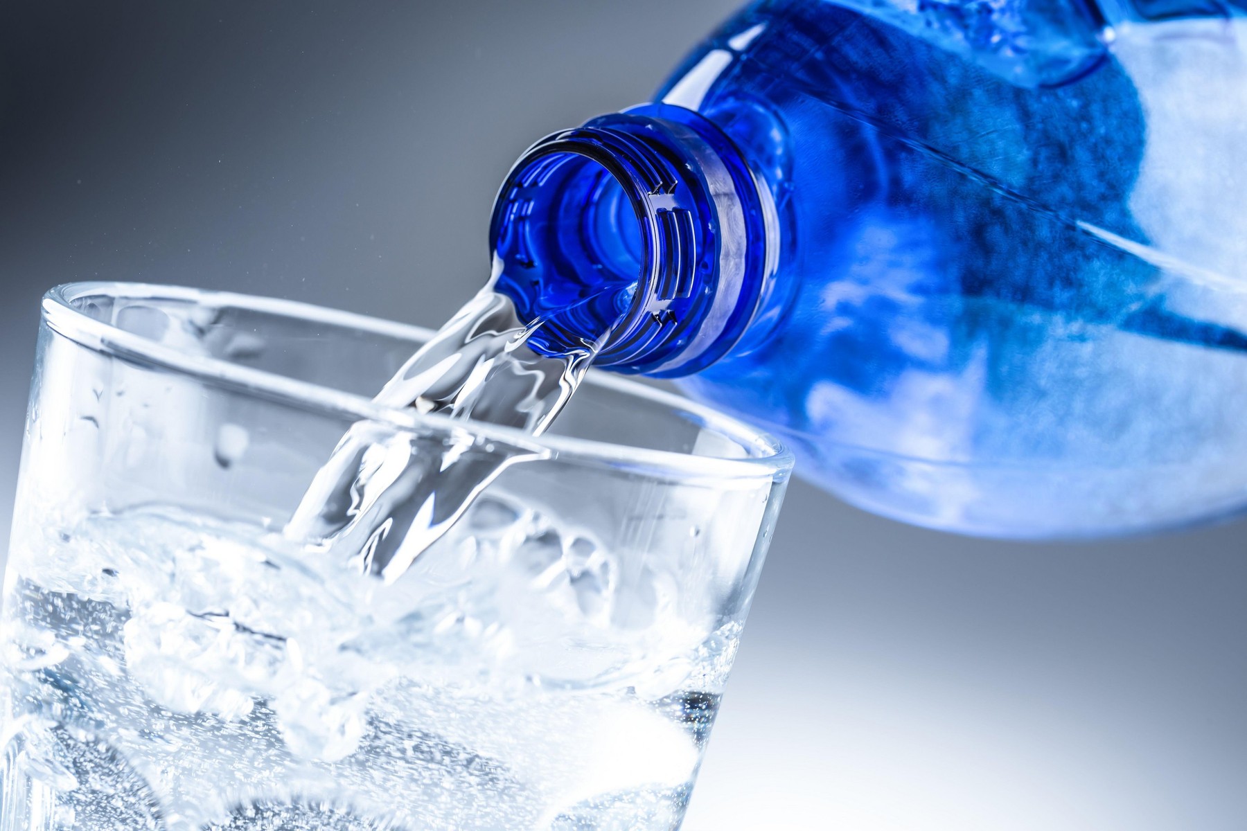 Pouring mineral water from blue bottle into clear glass on abstract grey background.,Image: 509975296, License: Royalty-free, Restrictions: , Model Release: no, Credit line: Weyo / Alamy / Alamy / Profimedia