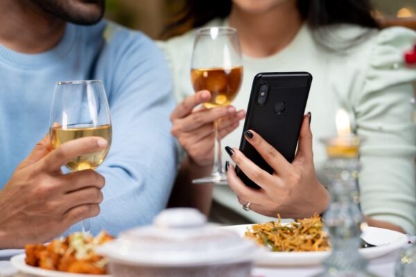 close up shot of couple hands using mobile phone by having drinks during candlelight dinner - concept of wedding anniversary celebration, cyberspace and dating application.,Image: 755088609, License: Royalty-free, Restrictions: , Model Release: no, Credit line: lakshmiprasad S / Alamy / Alamy / Profimedia