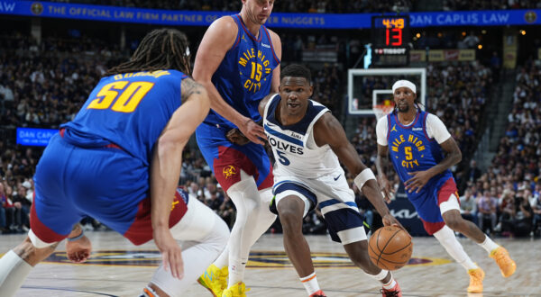 Minnesota Timberwolves guard Anthony Edwards (5) drives past Denver Nuggets center Nikola Jokic (15) as forward Aaron Gordon (50) blocks the lane in the second half of Game 1 of an NBA basketball second-round playoff series Saturday, May 4, 2024, in Denver. (AP Photo/David Zalubowski)