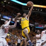 Indiana Pacers forward Obi Toppin (1) drives to the basket over New York Knicks center Isaiah Hartenstein (55) and forward Precious Achiuwa (5) during the second half of Game 6 in an NBA basketball second-round playoff series, Friday, May 17, 2024, in Indianapolis. (AP Photo/Michael Conroy)