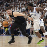 Dallas Mavericks guard Luka Doncic (77) drives against Minnesota Timberwolves guard Anthony Edwards (5) during the first half of Game 2 of the NBA basketball Western Conference finals, Friday, May 24, 2024, in Minneapolis. (AP Photo/Abbie Parr)