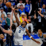 Dallas Mavericks guard Luka Doncic, left, compete for a jump ball against Minnesota Timberwolves guard Anthony Edwards (5) during the second half in Game 3 of the NBA basketball Western Conference finals, Sunday, May 26, 2024, in Dallas. (AP Photo/Gareth Patterson)