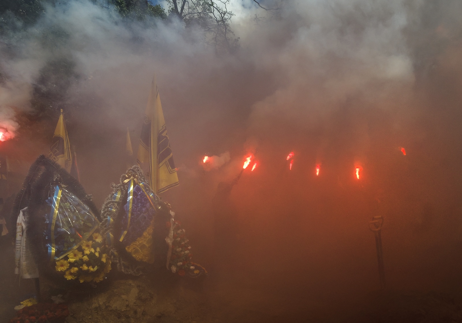 epa11324686 Comrades burn flares during the funeral ceremony of late Ukrainian serviceman Andrii Levashov at the Alley of Heroes of Lukyanivske cemetery in Kyiv, Ukraine, 07 May 2024. Andrii Levashov, 23, nicknamed 'Koldun (Wizard)', served in the Special Purpose Brigade of the Ukrainian National Guard 'Azov'. He died during fighting near Lyman, in the Donetsk region, amid the Russian invasion. Russian troops entered Ukrainian territory on 24 February 2022, starting a conflict that has provoked destruction and a humanitarian crisis.  EPA/SERGEY DOLZHENKO