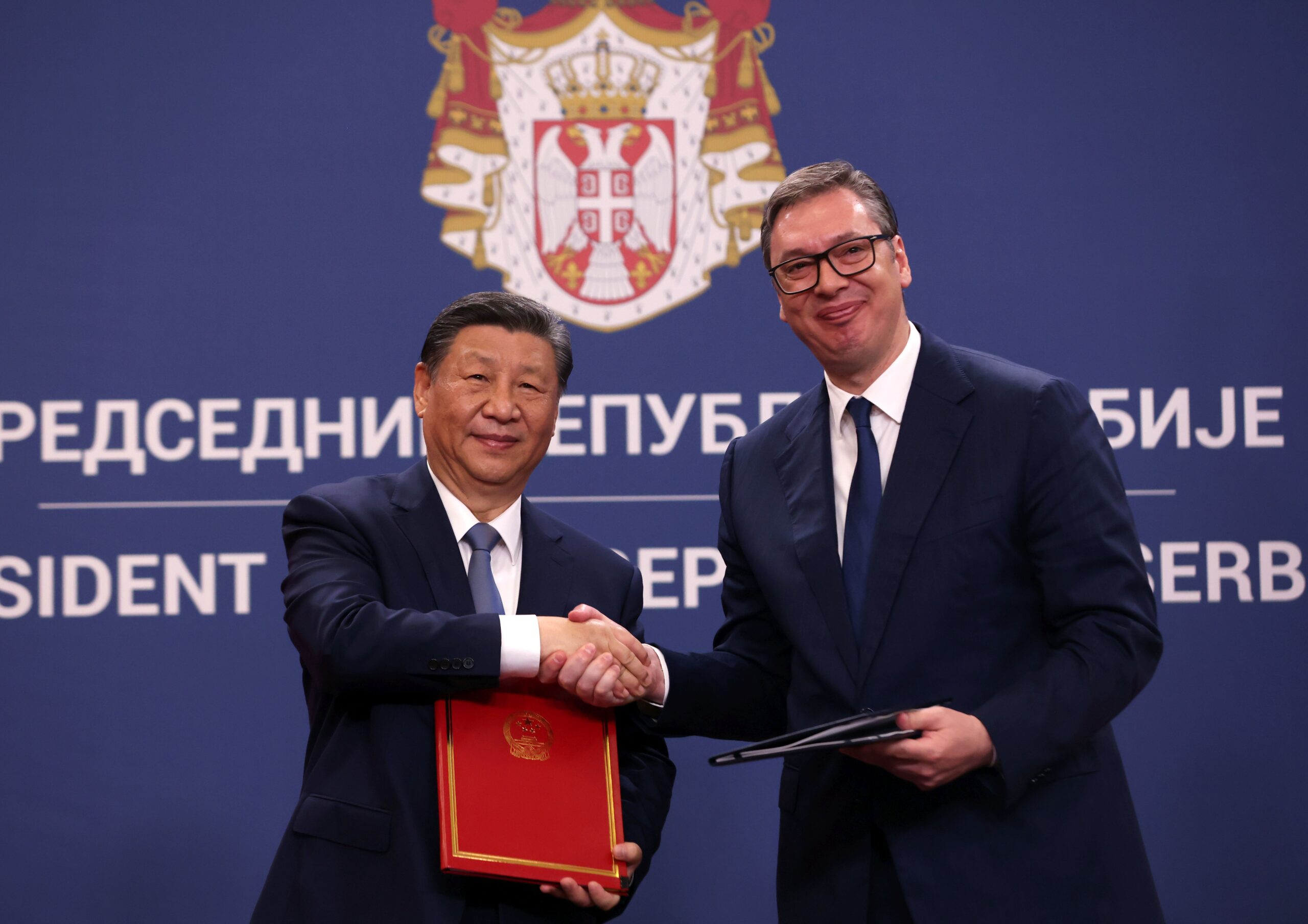 epa11326519 Serbian President Aleksandar Vucic (R) and Chinese President Xi Jinping (L) shake hands after signing an agreement of understanding between Serbia and China in Belgrade, Serbia, 08 May 2024. The Chinese president is on a two-day official visit to Serbia.  EPA/ANDREJ CUKIC